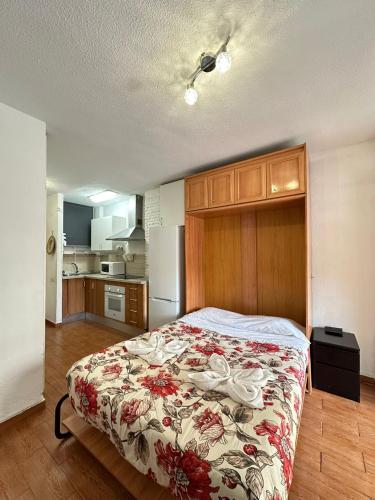 una camera da letto con un letto con copriletto floreale di Apartamentos Gamonal Costa del Sol a Málaga