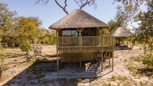 Un cenador con una choza de paja en un campo en Chobe Hideaway, en Kasinka