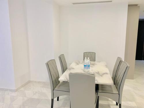 a dining room table with chairs and a white tablecloth at Eaton Residences By Classic in Kuala Lumpur