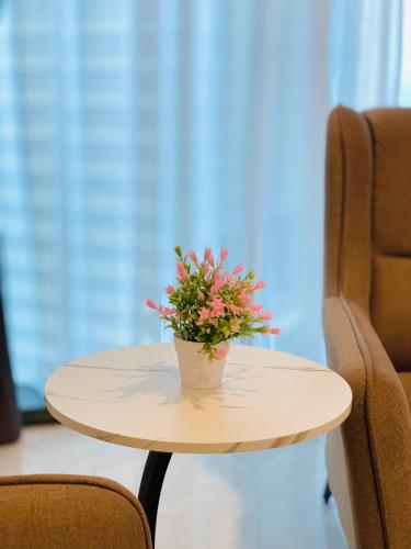 a small white table with a potted plant on it at Eaton Residences By Classic in Kuala Lumpur