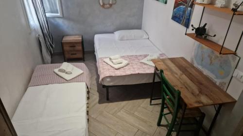 a small room with two beds and a table at a due passi dal mare in Campofelice di Roccella