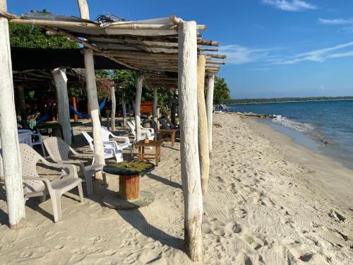 a beach with chairs and a bar on the beach at Taida Hostel Rincón del Mar in Rincón