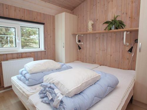 two beds in a room with wooden walls and a window at Luxury Pool House in Lonstrup - By Traum Ferienwohnungen in Lønstrup