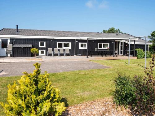 a black building with a picnic table in a yard at Luxury Pool House in Lonstrup - By Traum Ferienwohnungen in Lønstrup