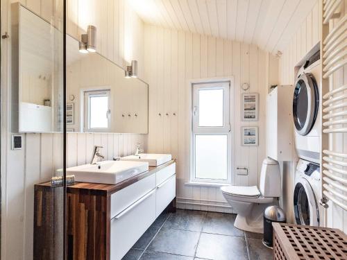 a bathroom with a sink and a washing machine at Luxury Pool House in Lonstrup - By Traum Ferienwohnungen in Lønstrup