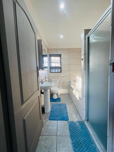 a bathroom with a shower and a toilet and a sink at Affordable Modern Stay in Vanderbijlpark