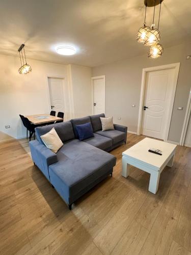 a living room with a blue couch and a table at Sea View Apartment in Durrës