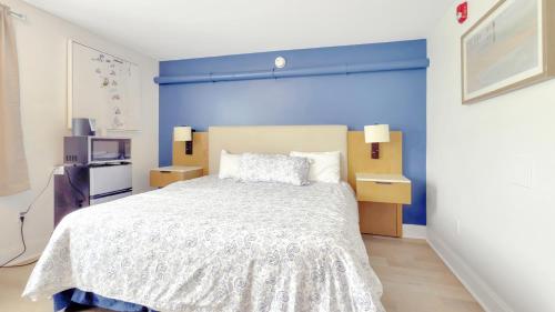 a bedroom with a large bed with a blue wall at Harborline Hotel in Rockland