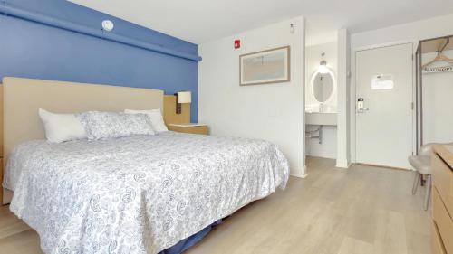 a bedroom with a bed with a blue wall at Harborline Hotel in Rockland