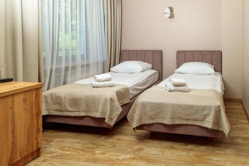 two beds sitting next to each other in a room at Hotel Echo in Cedzyna