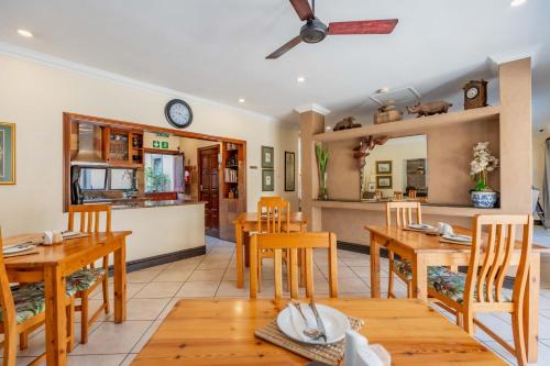 ダーバンにあるThe Villa Umhlangaの木製のテーブルと椅子のあるダイニングルーム