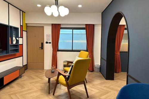 a living room with a yellow chair and a table at Parcel Hotel Bangkok in Bangkok