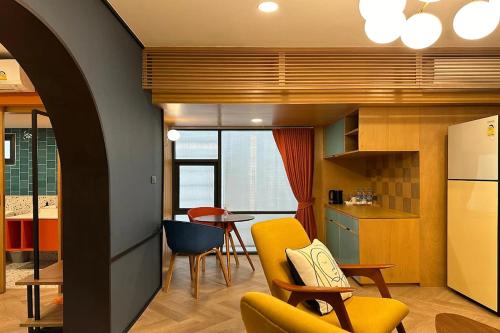 a kitchen with a yellow chair and a table at Parcel Hotel Bangkok in Bangkok