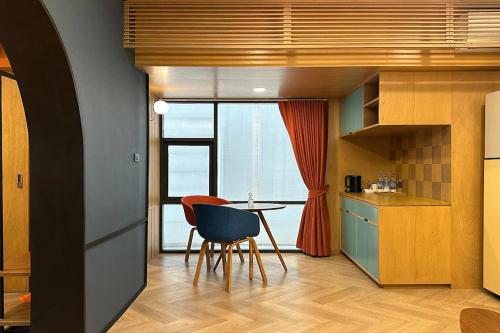 a kitchen with a table and a chair and a window at Parcel Hotel Bangkok in Bangkok