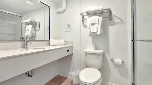 a bathroom with a toilet and a sink and a mirror at Harborline Hotel in Rockland