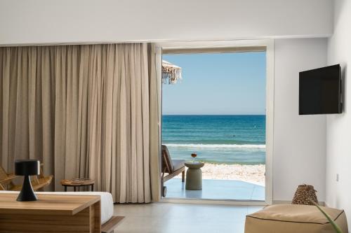 a living room with a view of the beach at Acharavi Beach Hotel in Acharavi