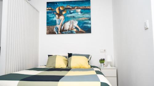 Un dormitorio con una cama con un cuadro en la pared. en Studio New Complete 4 pax, en Madrid