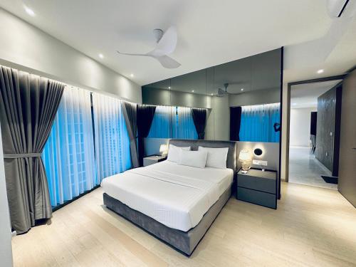 a bedroom with a large bed and blue curtains at Eaton Residences By Classic in Kuala Lumpur