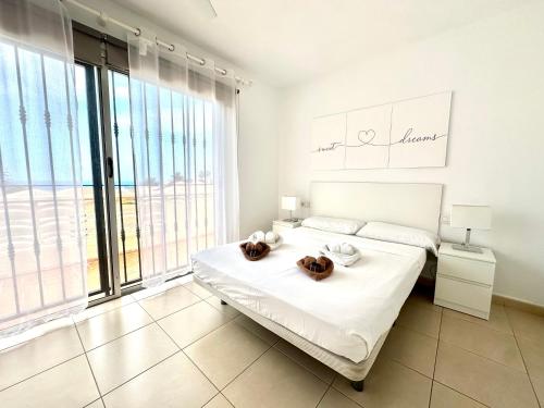 a white bedroom with a bed and a large window at DUPLEX C6 con PISCINA PRIVADA in Callao Salvaje