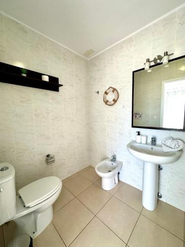 a white bathroom with a toilet and a sink at DUPLEX C6 con PISCINA PRIVADA in Callao Salvaje