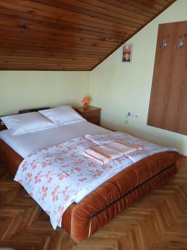 1 cama en un dormitorio con techo de madera en HOSTEL BATA APARTMANI, en Kanjiža