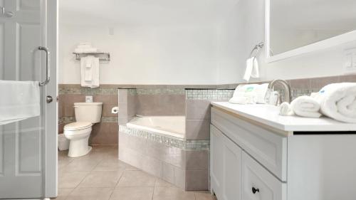 a bathroom with a tub and a toilet and a sink at Harborline Hotel in Rockland