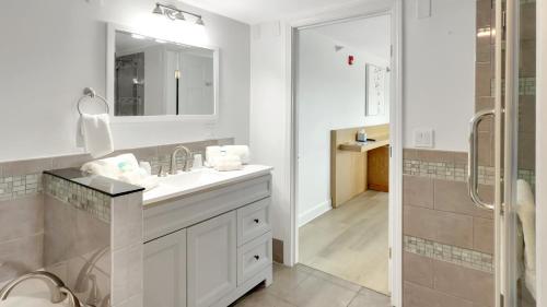 a white bathroom with a sink and a shower at Harborline Hotel in Rockland