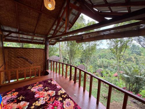 a wooden porch with a bed on a balcony at Hide and Seek in Tetebatu