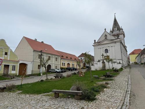 a street with a church and a bench in a town at Pálava Chalupa in Pavlov