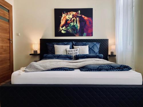 a bedroom with a bed with a painting on the wall at Centrum Vendégház in Miskolc