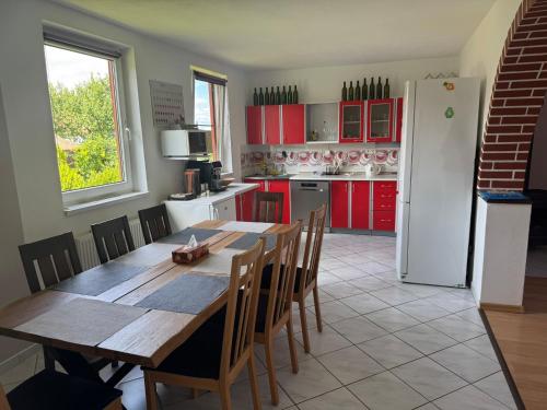 a kitchen with a wooden table and a kitchen with red cabinets at Pálava Chalupa in Pavlov