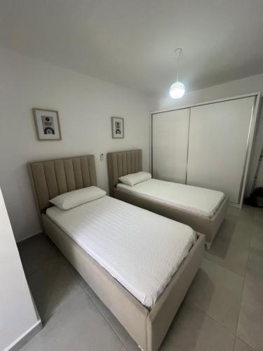 two beds sitting in a room withermottermottermott at Sea View Apartment in Durrës