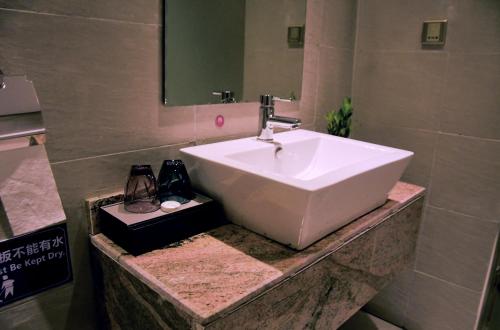 ein Badezimmer mit einem weißen Waschbecken und einem Spiegel in der Unterkunft Wealth Hotel Ikeja in Ikeja