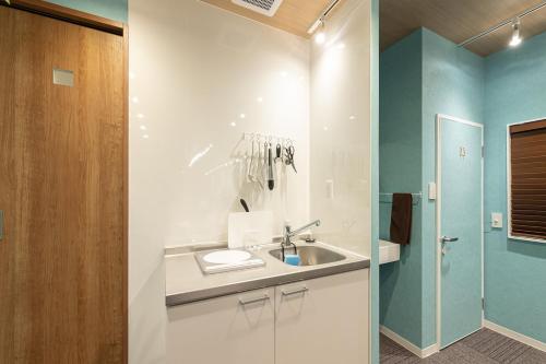 a bathroom with a sink and a shower at TasoneUrbanStayOsaka 梅田北EFB2F in Wada