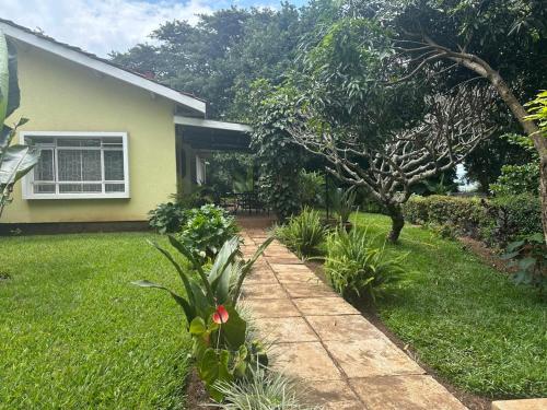 アルーシャにあるAvana Homeの歩道のある芝生の庭のある家