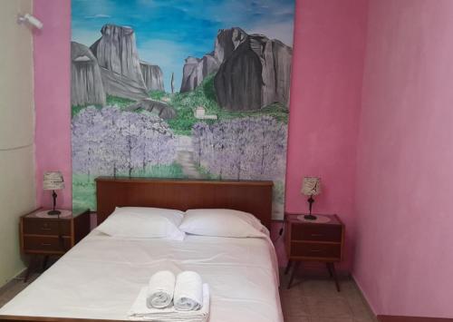 a bedroom with a bed with a painting on the wall at Farmhouse Meteora Garden in Kastraki