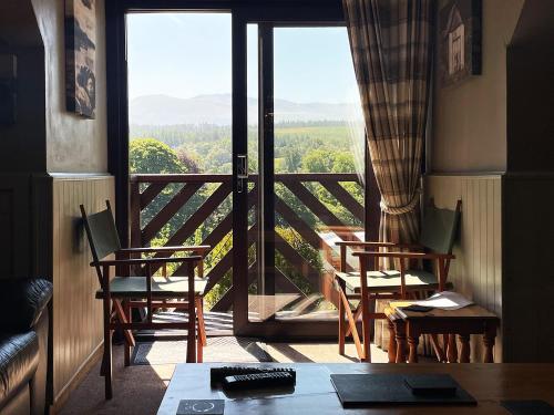 ein Raum mit Tisch und Stühlen und einem großen Fenster in der Unterkunft Corrieview Lodges in Spean Bridge