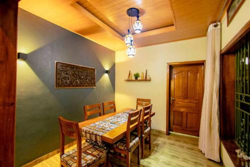 comedor con mesa, sillas y puerta en Backpackers Lodge, en Kigali