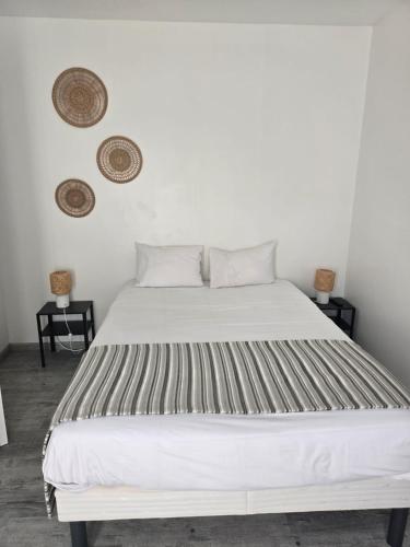 a white bed in a room with two baskets on the wall at The Originals City, le Beaujoire, Nantes - FACE Parc Expo et FACE Stade Beaujoire in Nantes