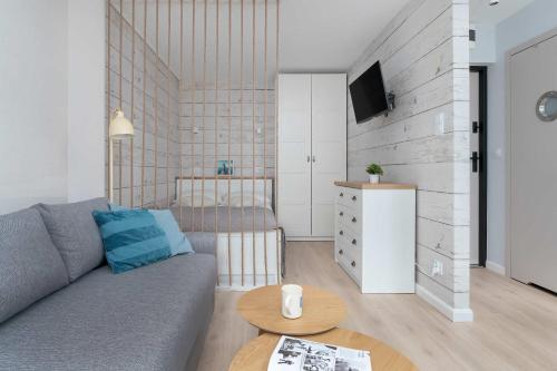 una sala de estar con un sofá y una mesa en Baltic Studio 15 minutes from the Beach by Noclegi Renters, en Gdansk