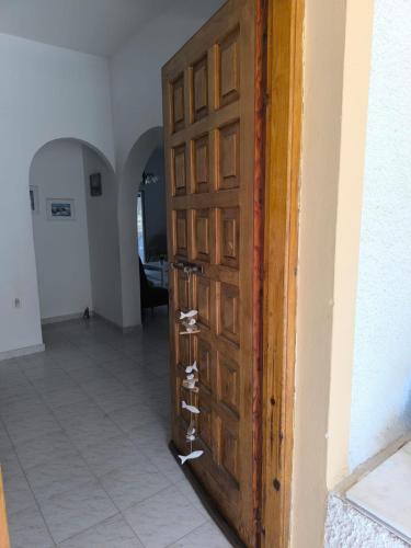 a wooden door in a room with a hallway at Maria's Home Aegina in Kondós