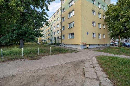an empty street in front of a yellow building at Baltic Studio 15 minutes from the Beach by Noclegi Renters in Gdańsk