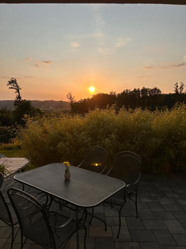 a table and chairs with the sunset in the background at Kleines WaldGlück Wennemen in Meschede