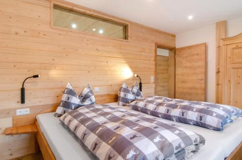 two beds in a room with wooden walls at Pension Ferienwohnung Baarblick in Donaueschingen