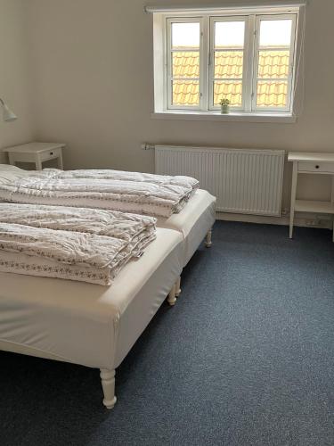 two beds in a room with two windows at Korinth Kro Hostel - Betjeningsfrit vandrehjem in Fåborg