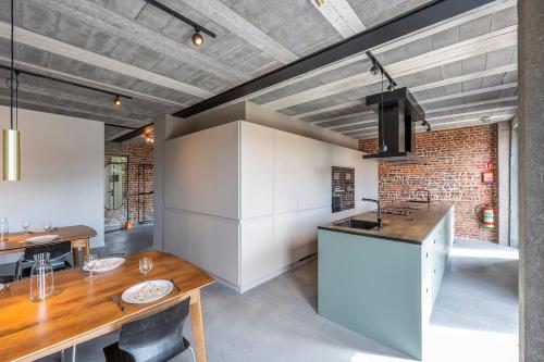 a kitchen with a table and a counter top at Pachthof 1860 in Sint-Pieters-Leeuw
