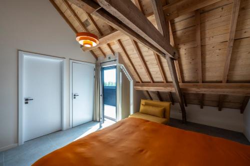 a bedroom with a large bed in a room with wooden ceilings at Pachthof 1860 in Sint-Pieters-Leeuw