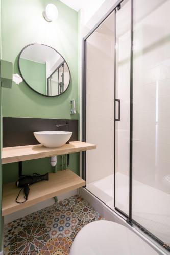 a bathroom with a sink and a mirror at The Originals City, le Beaujoire, Nantes - FACE Parc Expo et FACE Stade Beaujoire in Nantes