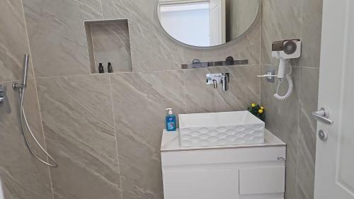 une salle de bain avec un lavabo et un miroir dans l'établissement Dashaj Rooms 304, à Ksamil