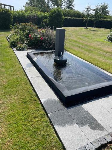 a fountain in the middle of a garden at Luxury Country House In Nature With Wellness in Haderslev